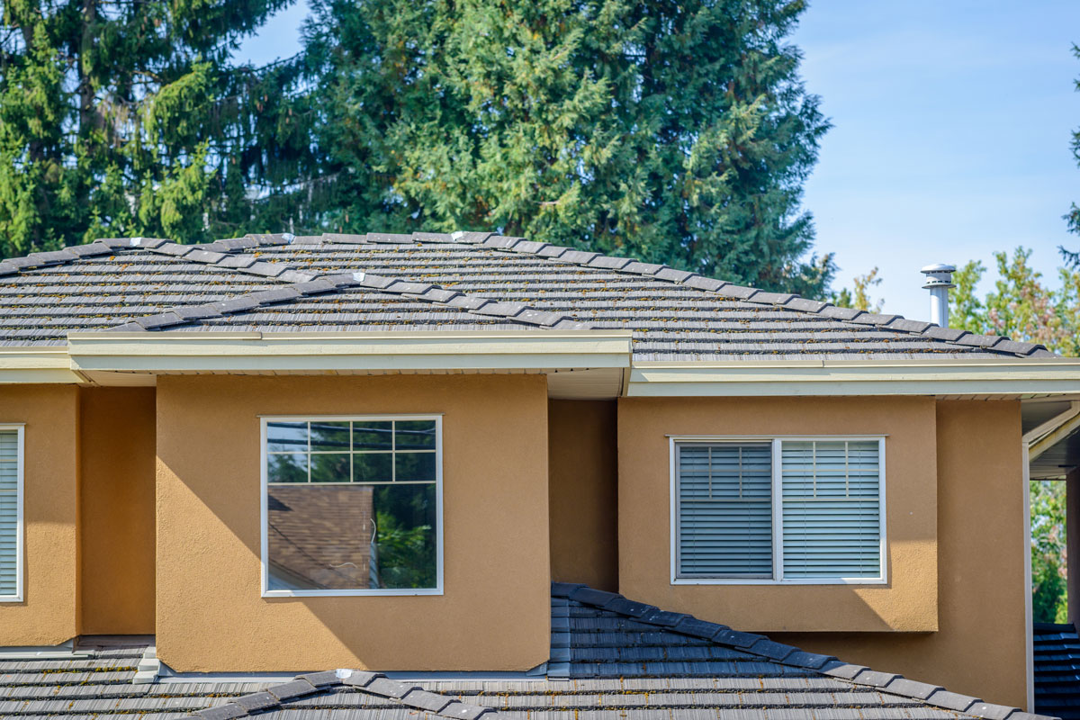 A house with a shingled roof in a neighborhood
