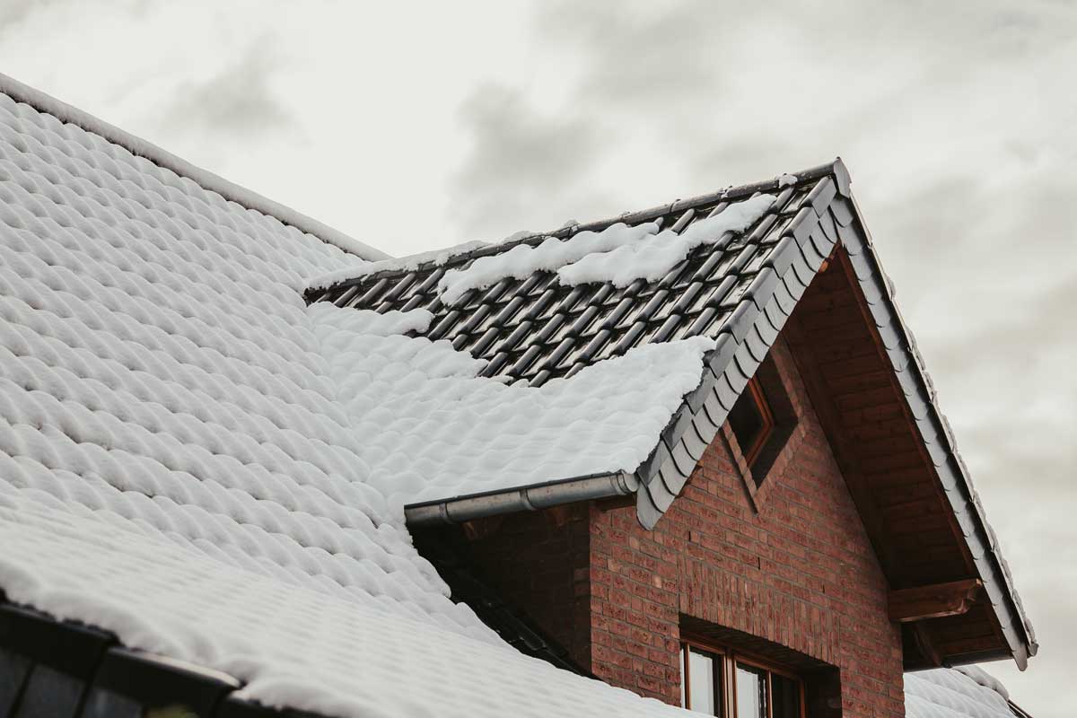 The roof of a house with ice and snow on it.