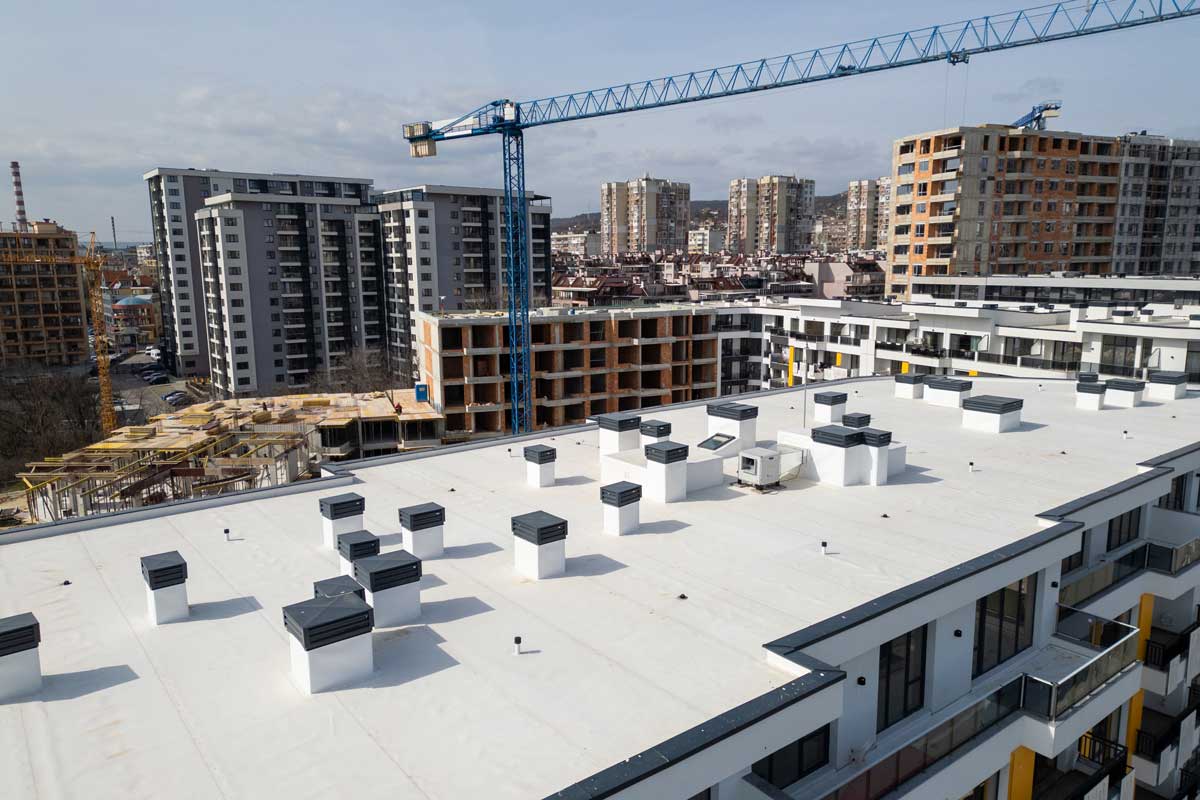 Aerial View of Modern Apartment Roof with Chimneys and Urban Skyline