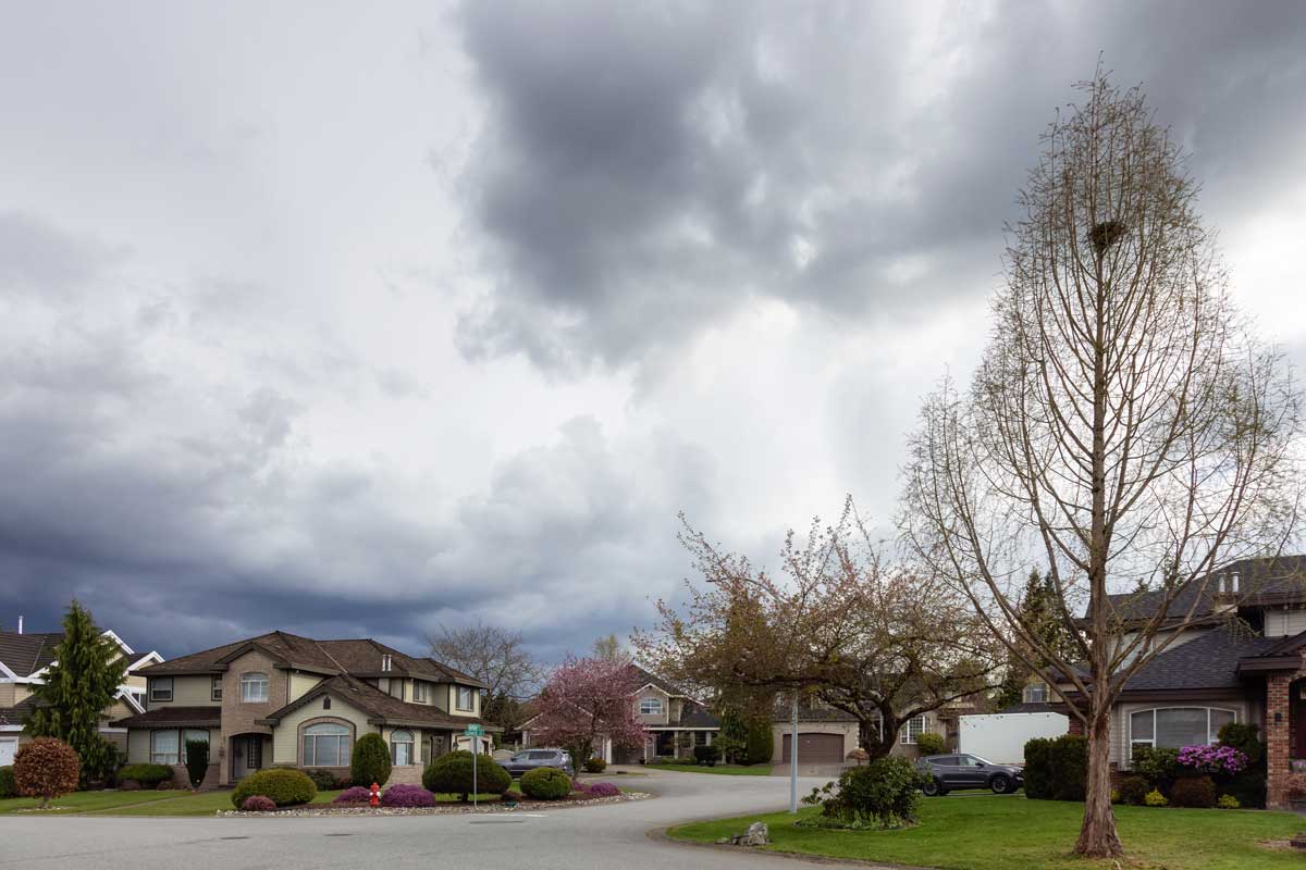 Residential neighborhood street with cloudy, stormy sky and clouds